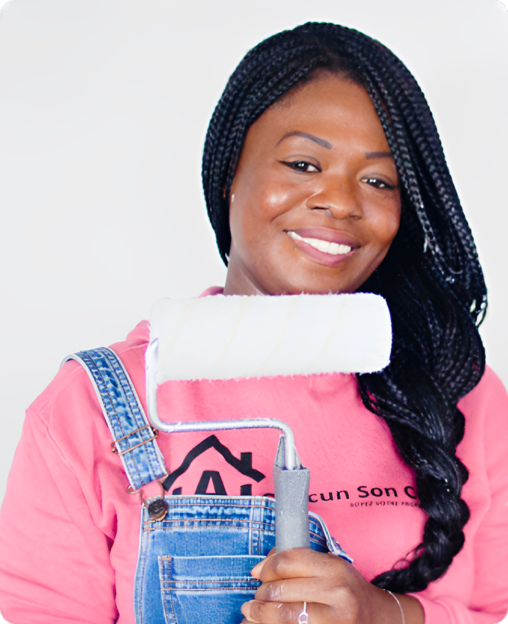 La fondatrice de l’association, souriante, un rouleau de peinture à la main, en sweat A Chacun Son Cocon