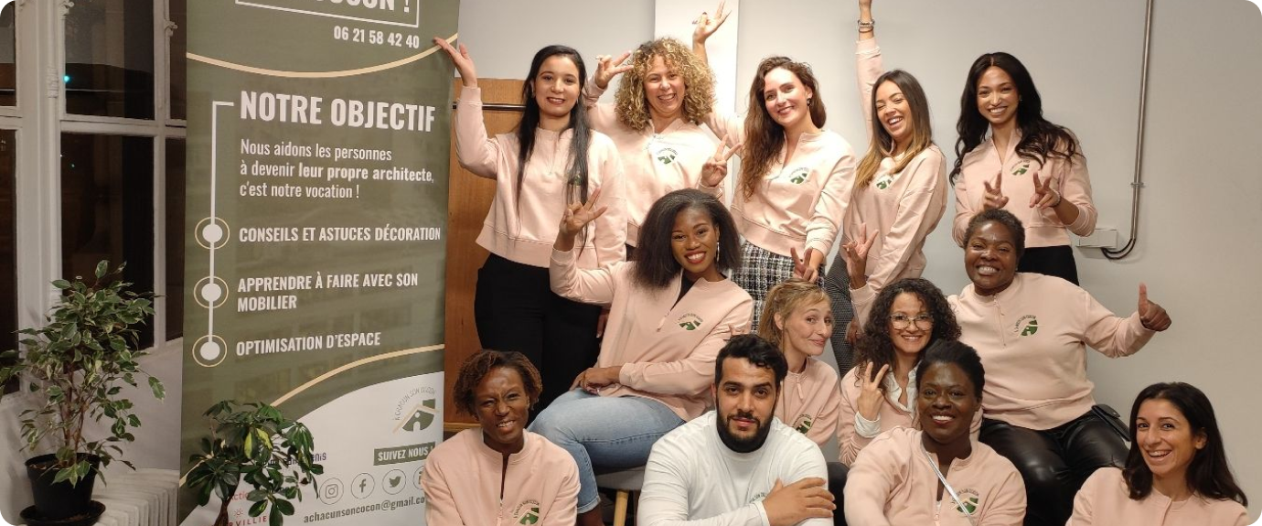 L’équipe d’A Chacun Son Cocon, en sweats de l’association, réunie à côté du kakémono « Notre objectif » qui présente les conseils déco, l’apprentissage avec son mobilier et l’optimisation d’espace